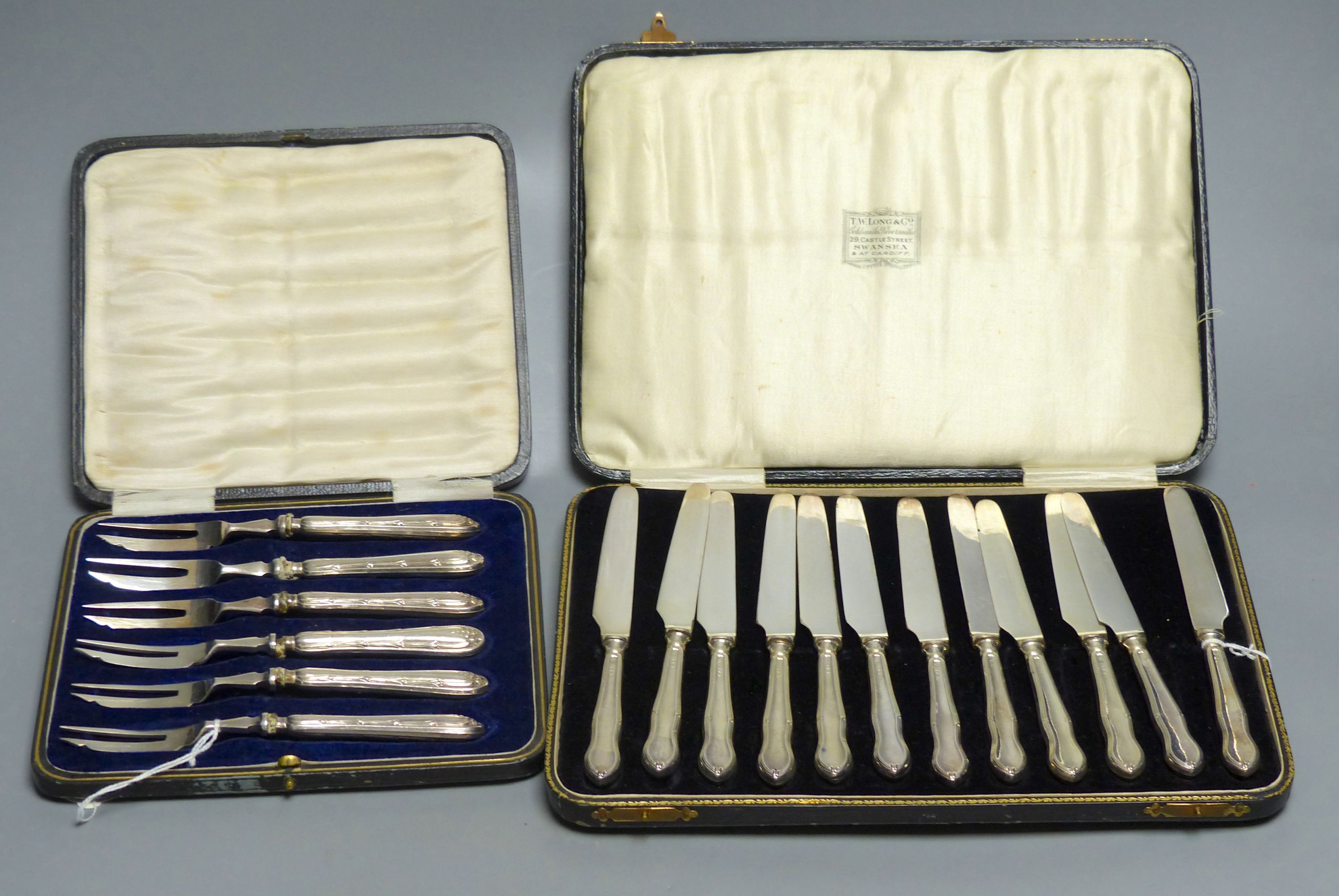 A cased set of twelve silver-handled dessert knives and a cased set of six similar cake forks (Sheffield 1919)